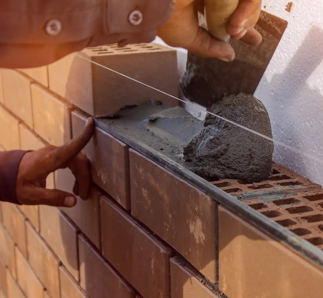 Maurer mit Kelle beim Aufbau einer Mauer